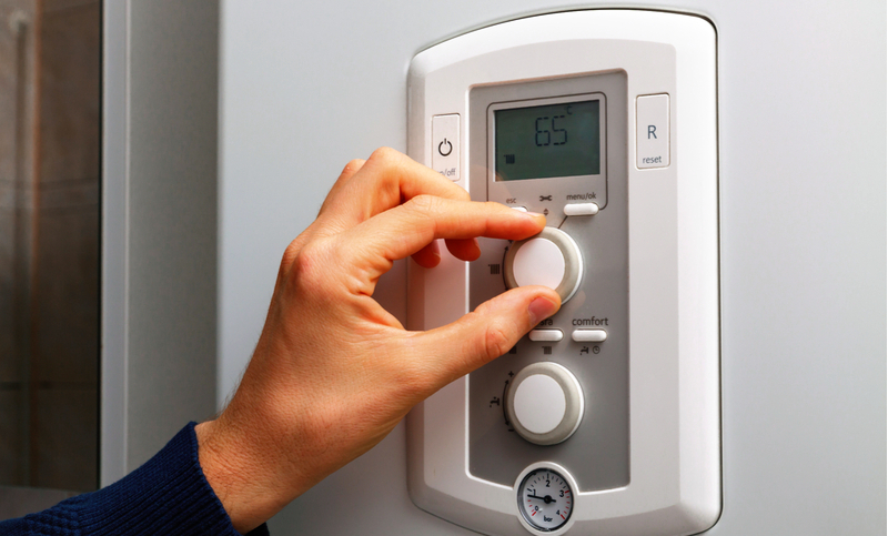 a person adjusting the thermostat