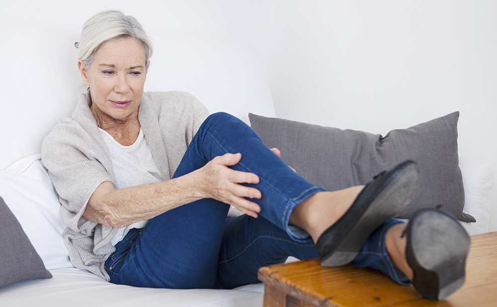 an old woman holding her right leg